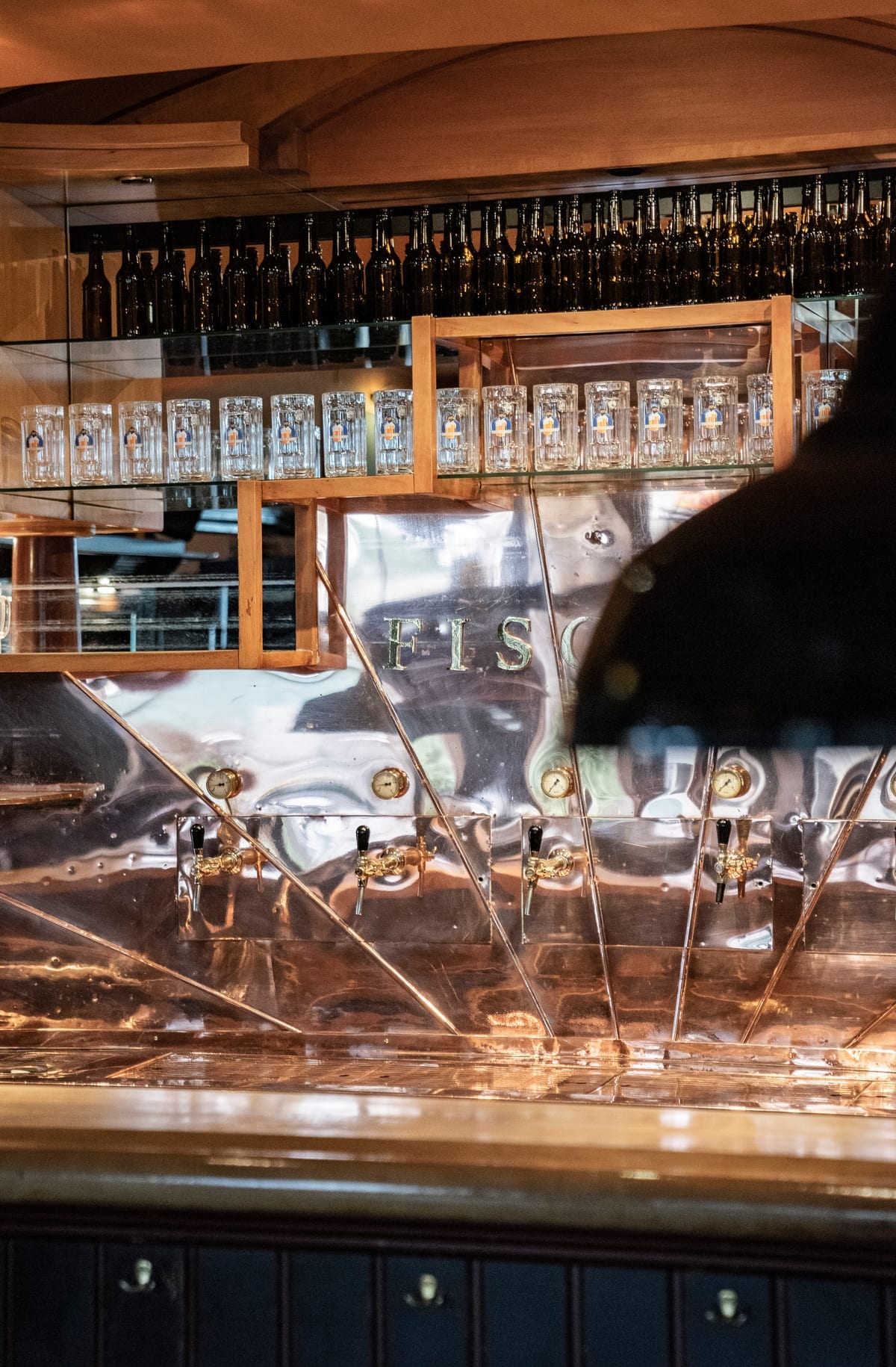 Beer taps and bar at Fischerbräu Vienna – traditional brewery tap system with branded mugs